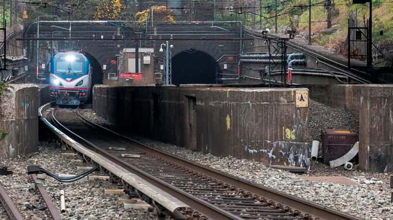 An Amtrak locomotive emerges from the North River Tunnel in...