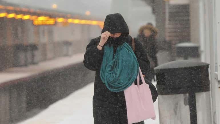 Commuters face snow and cold weather as they wait for...