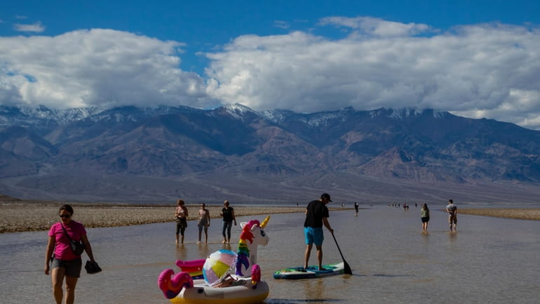 A paddle boarder tows an inflatable unicorn on a temporary...