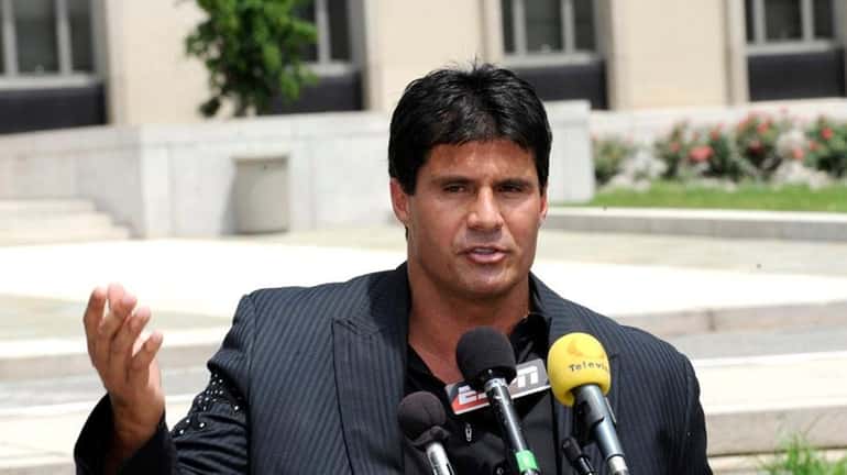 Jose Canseco talks to reporters after appearing in federal court...