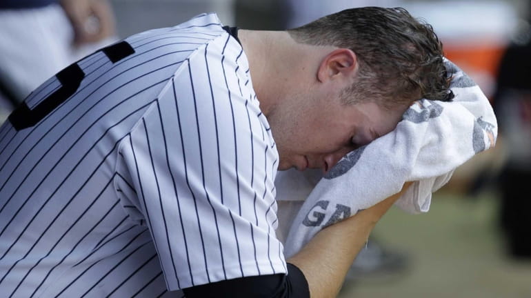 Yankees starting pitcher Phil Hughes wipes his face in the...
