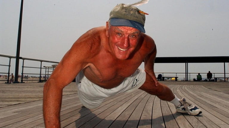 Jones, at age 76, does a one-arm pushup at the...