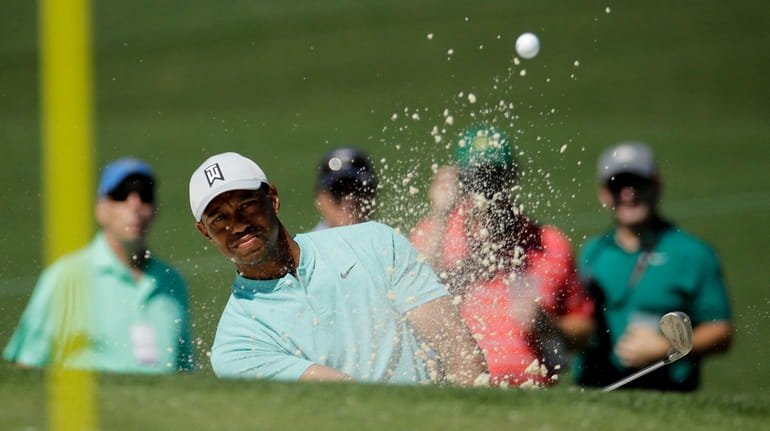 Tiger Woods hits out of the bunker on the second...