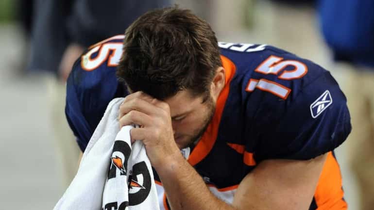 Tim Tebow prays during the final minute of the game...