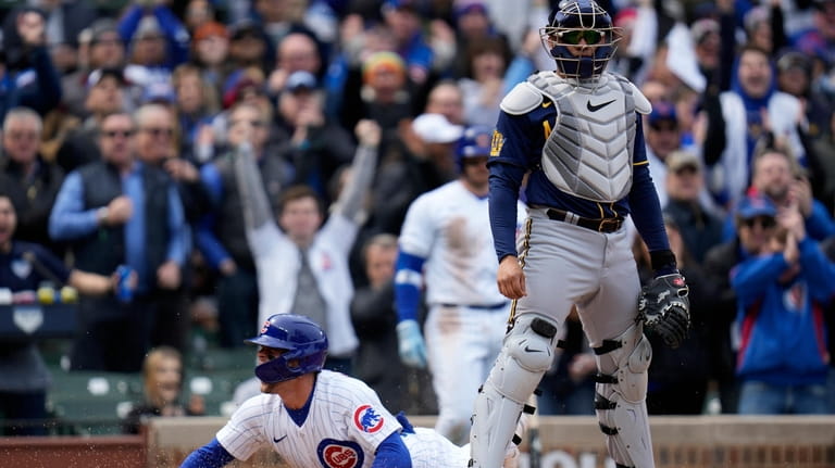 Chicago Cubs second baseman Nico Hoerner scores past Milwaukeee Brewers...