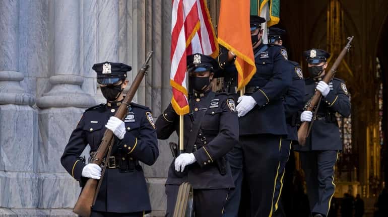 An NYPD honor guard leaves St. Patrick's Cathedral Monday following...