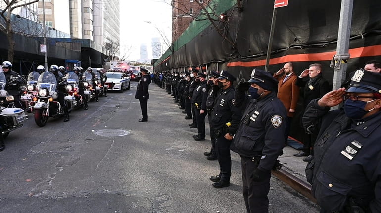 Members of the NYPD salute outside the New York City...