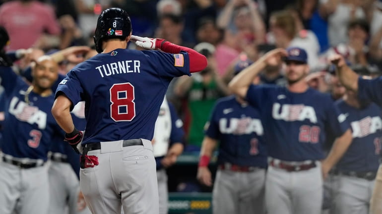U.S. 's Trea Turner (8) salutes his teammates after hitting...