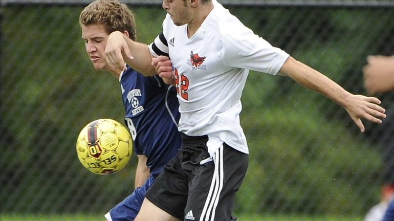 Half Hollow Hills East's Tyler Kirschner battles for possession with...