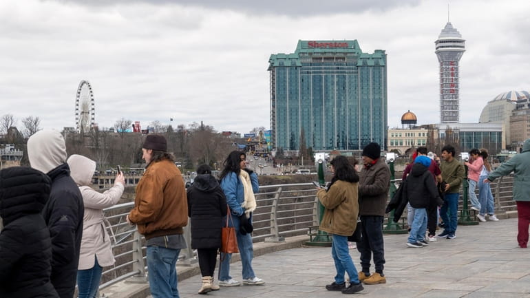 Tourists on the American side of Niagara Falls take photos...