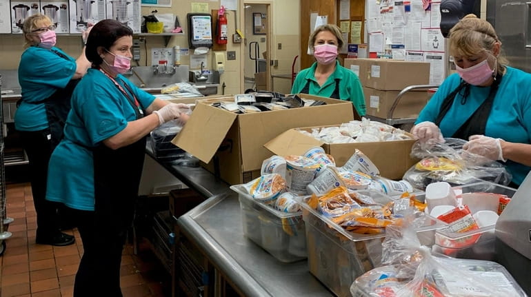Food service workers at Bellport High School in Brookhaven prepare take-home...