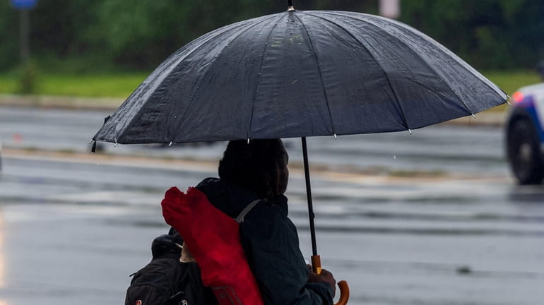 An umbrella is needed Monday in Central Islip as rain and...