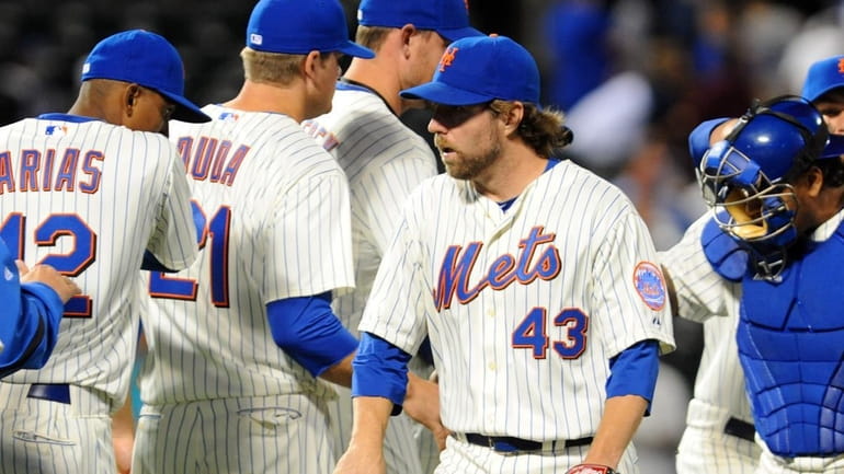 New York Mets' R.A. Dickey (43) is congratulated by teammates...