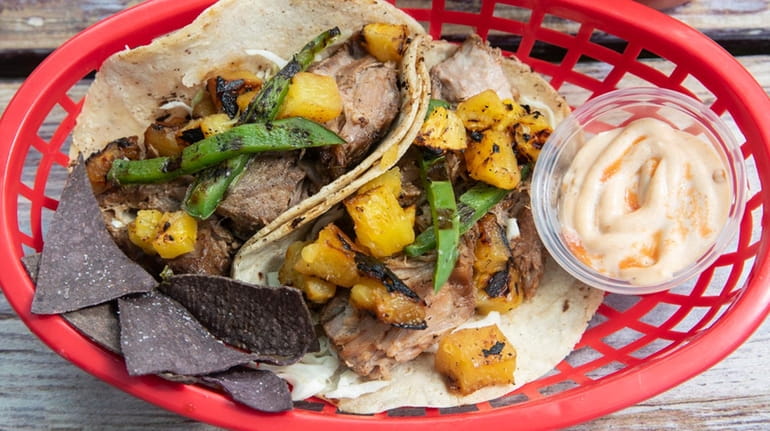 "Hawaiian" tacos are filled with pork carnitas and topped with grilled pineapple...