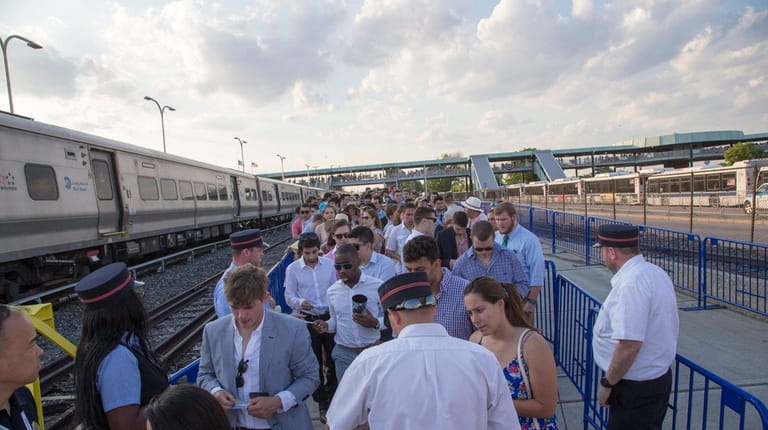 Race fans crowd the LIRR station as they leave the...
