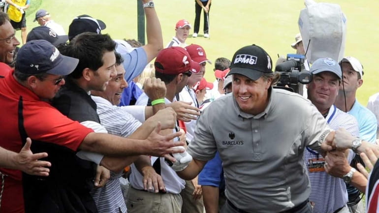 Phil Mickelson makes his way past adoring fans at the...
