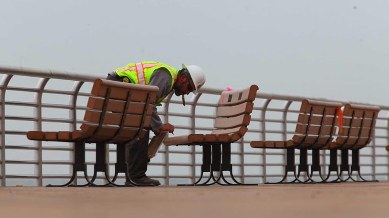 Workers put the finishing touches on the boardwalk in Long...