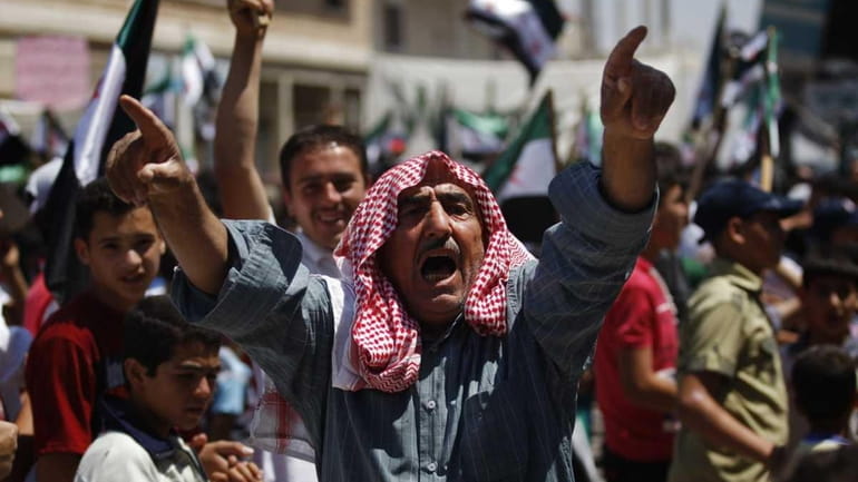 A Syrian man chants slogans during an anti-Bashar Assad protest...