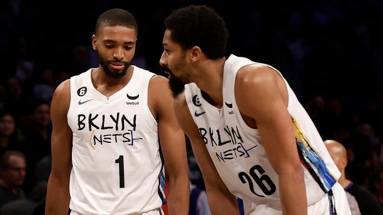 Mikal Bridges and Spencer Dinwiddie of the Nets react late during...