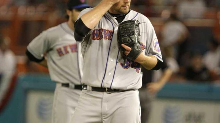 The Mets' Mike Pelfrey wipes his face during the fourth...
