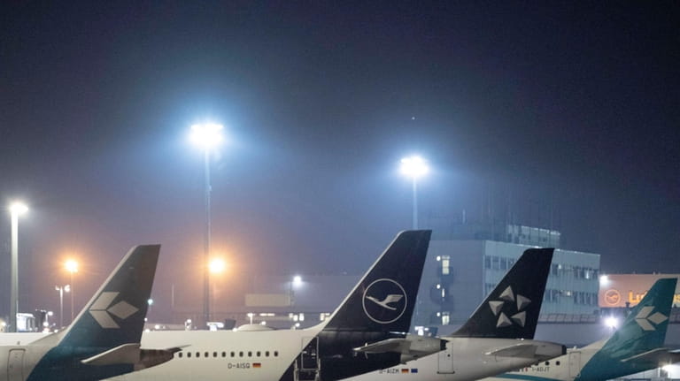 Passenger planes are parked at Frankfurt Airport, Germany, early Wednesday,...