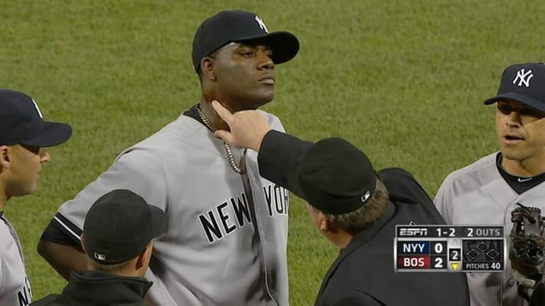 Home plate umpire Gerry Davis touches the neck of Yankees...