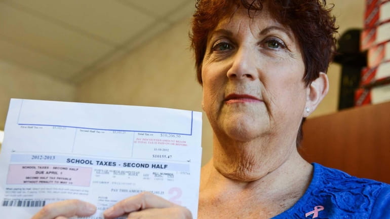 Leslie Spitzkoff stands with her tax bill inside her office...