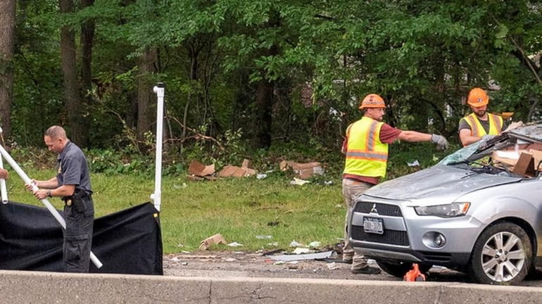 Investigators survey the scene of the crash on the Southern...