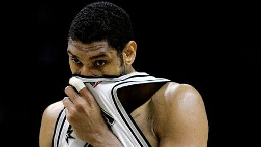 San Antonio Spurs forward Tim Duncan wipes his face as...