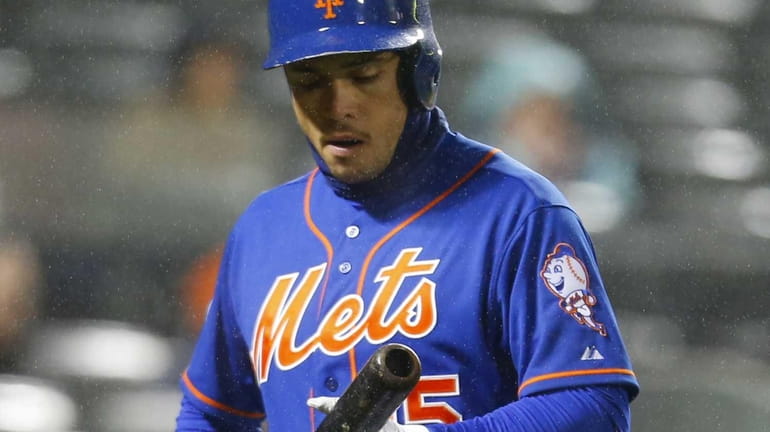 Travis d'Arnaud of the Mets walks back to the bench...