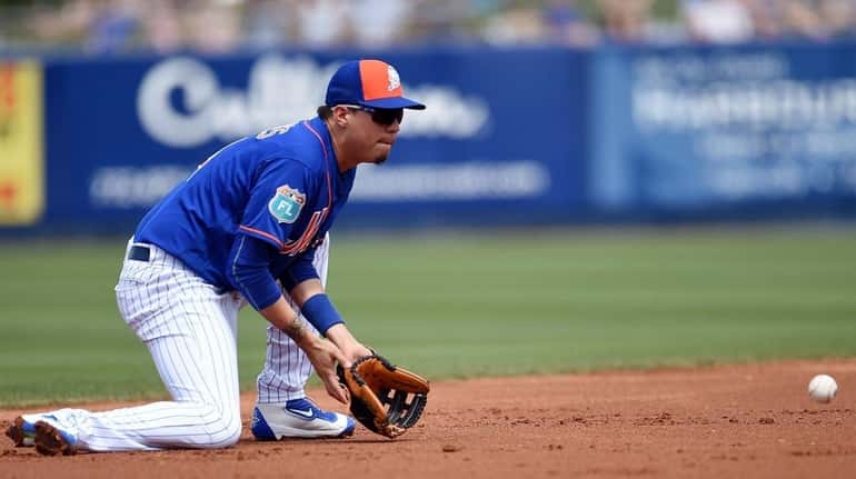 Wilmer Flores of the New York Mets fields a ground...