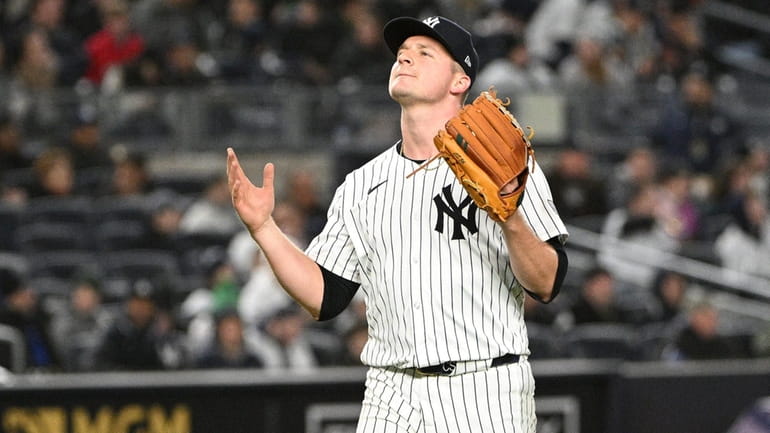 New York Yankees starting pitcher Clarke Schmidt reacts after being...