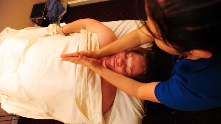 Christina Coke L.M.T. administers a prenatal massage to Danielle Butler...