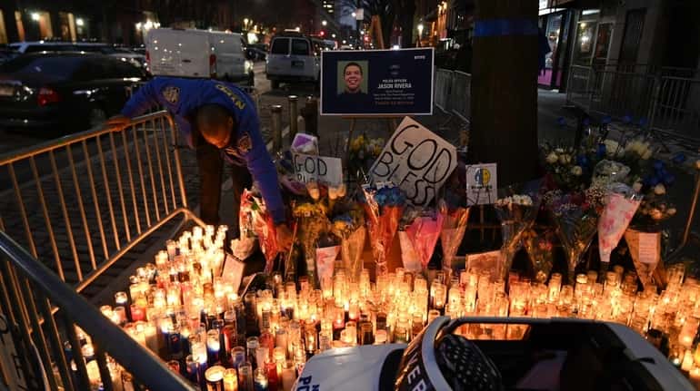 A memorial to Officer Jason Rivera grows in front of...