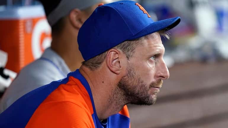 Mets pitcher Max Scherzer watches from the dugout during a...