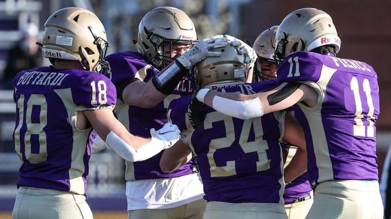 Sayville's Tom Cea is congratulated by teammates after scoring during...