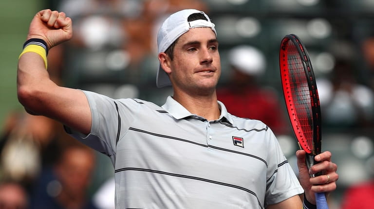 John Isner celebrates after his straight-sets victory against Hyeon Chung...