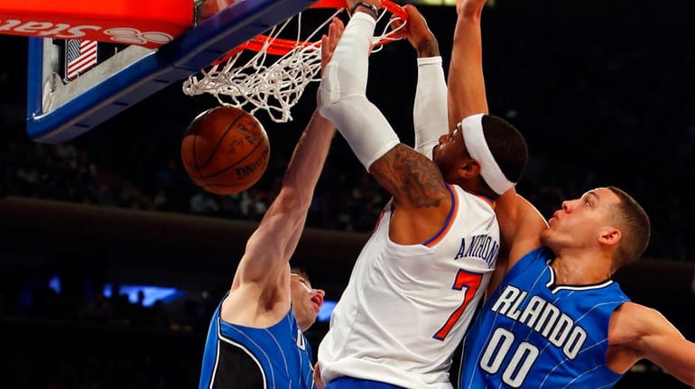 Carmelo Anthony goes into traffic and jams against Aaron Gordon,...