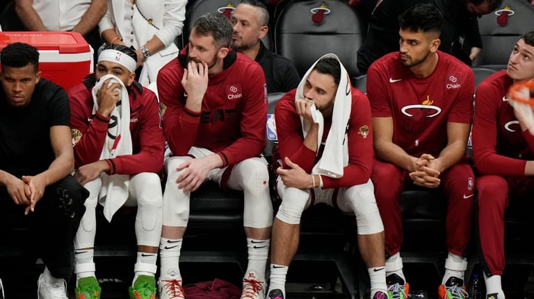 Miami Heat players sit on the bench at the end...
