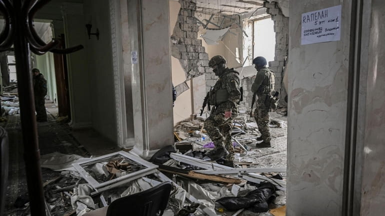 Ukranian soldiers walk inside the destroyed regional headquarters of Kharkiv...