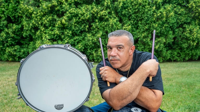 Musician Joey Cruz relaxing next to his congas and timbales. 