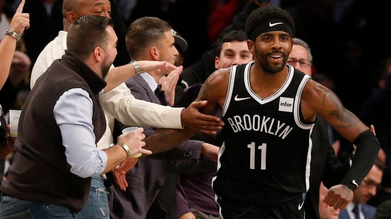 Kyrie Irving of the Nets reacts after a three-point shot in...