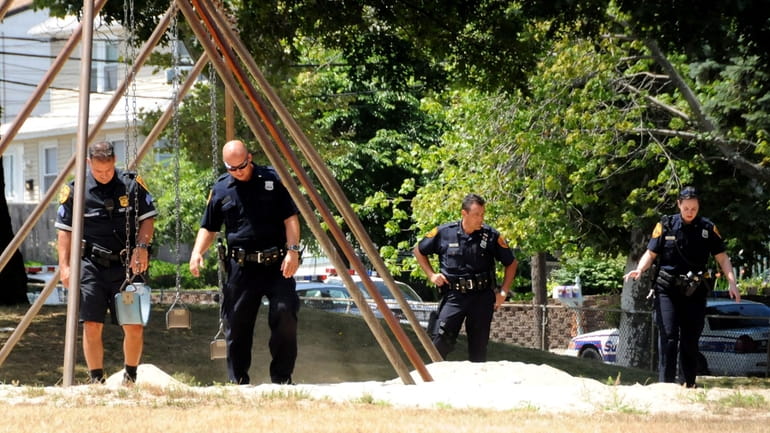Officers comb a playground for bullet shell casings in at...