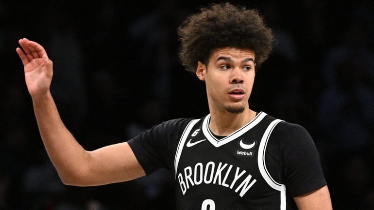 Nets forward Cameron Johnson looks on after sinking a three-point...
