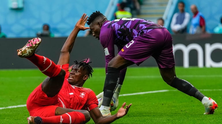 Switzerland's Breel Embolo reacts next to Cameroon's goalkeeper Andre Onana...