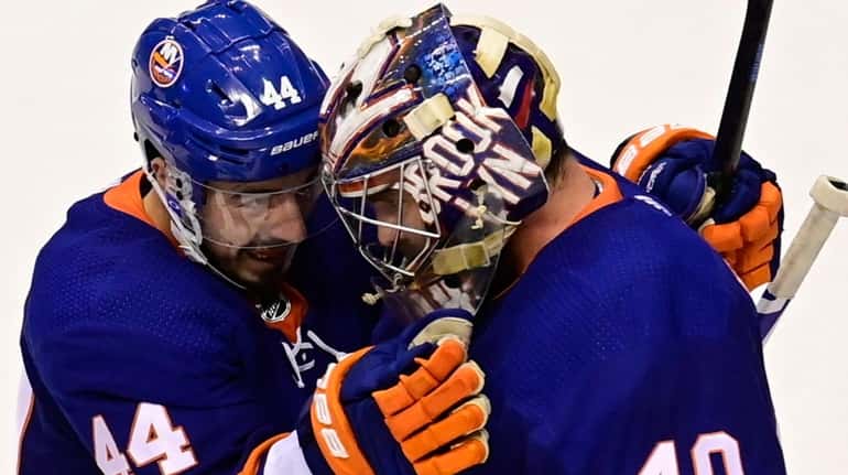 Islanders center Jean-Gabriel Pageau celebrates with goaltender Semyon Varlamov after defeating...