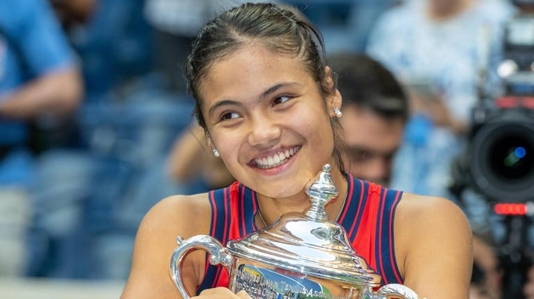 Emma Raducanu hugs her trophy in disbelief after defeating Leylah Fernandez...