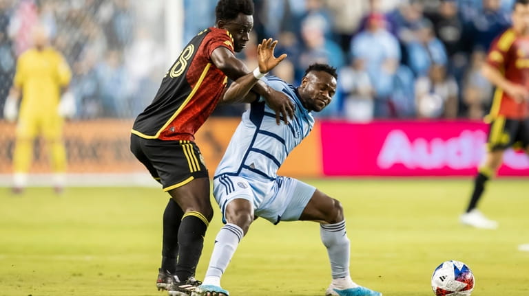 Sporting Kansas City forward Willy Agada, front right, leans into...