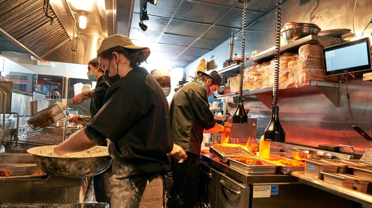 The kitchen is bustling with takeout orders at Hot Chicken...