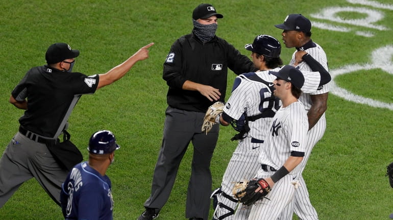 Aroldis Chapman of the Yankees is restrained as walks over to...